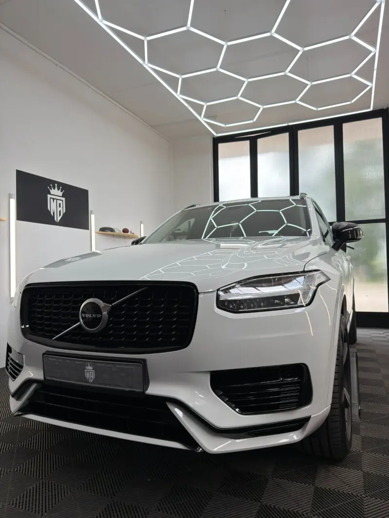 Weißer Volvo mit glänzendem Lack unter der Wabenbeleuchtung